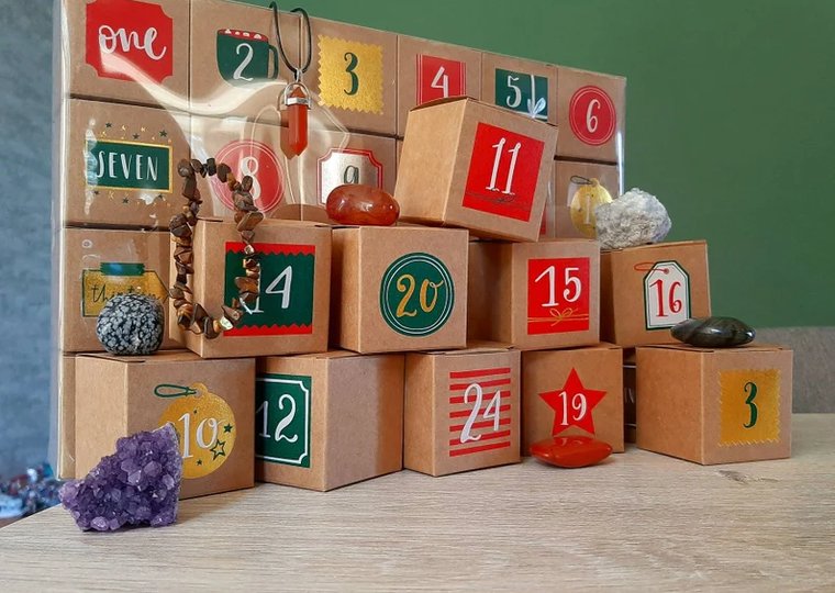 Edelstenen-adventskalender van Jume Crystals: 24 genummerde kartonnen doosjes met kerstprint, met losse edelstenen ervoor