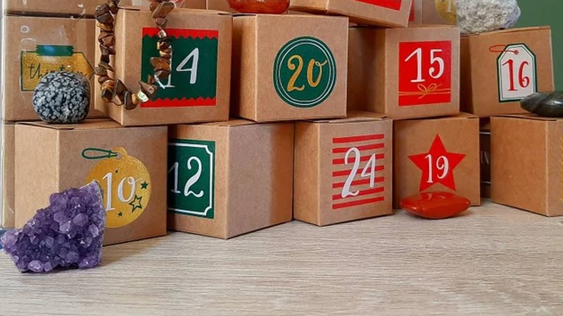 Genummerde kartonnen doosjes van een adventskalender met losse edelstenen ervoor